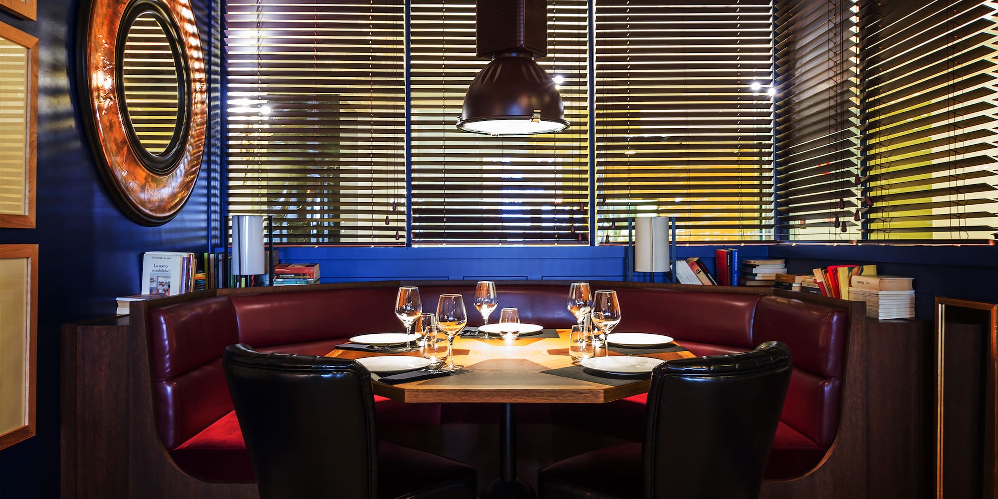 a table with wine glasses and chairs in a restaurant