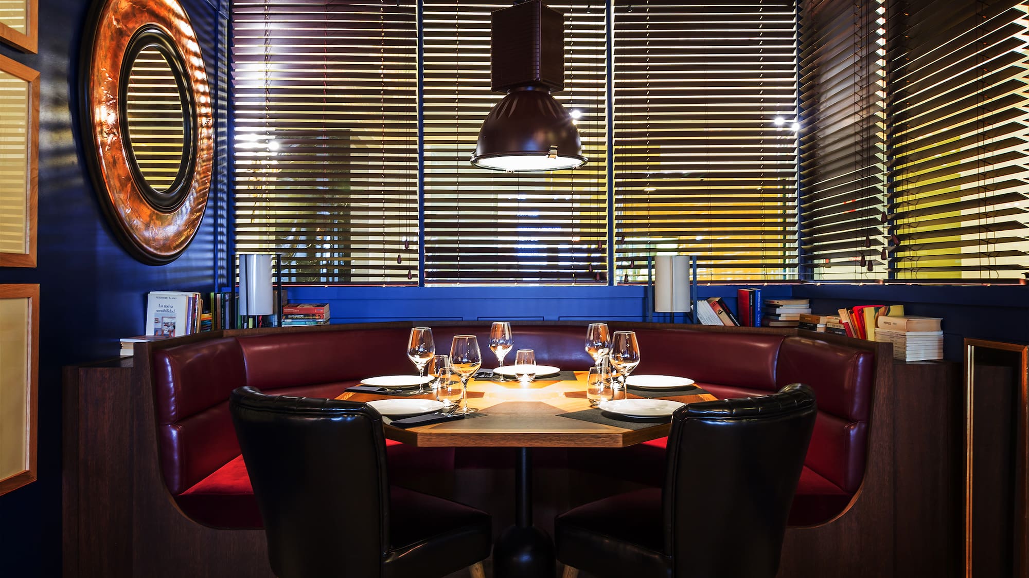a table with wine glasses and chairs in a restaurant