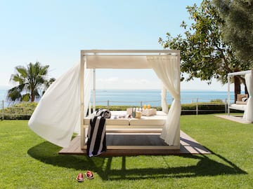 a white canopy on a wooden deck with a beach view