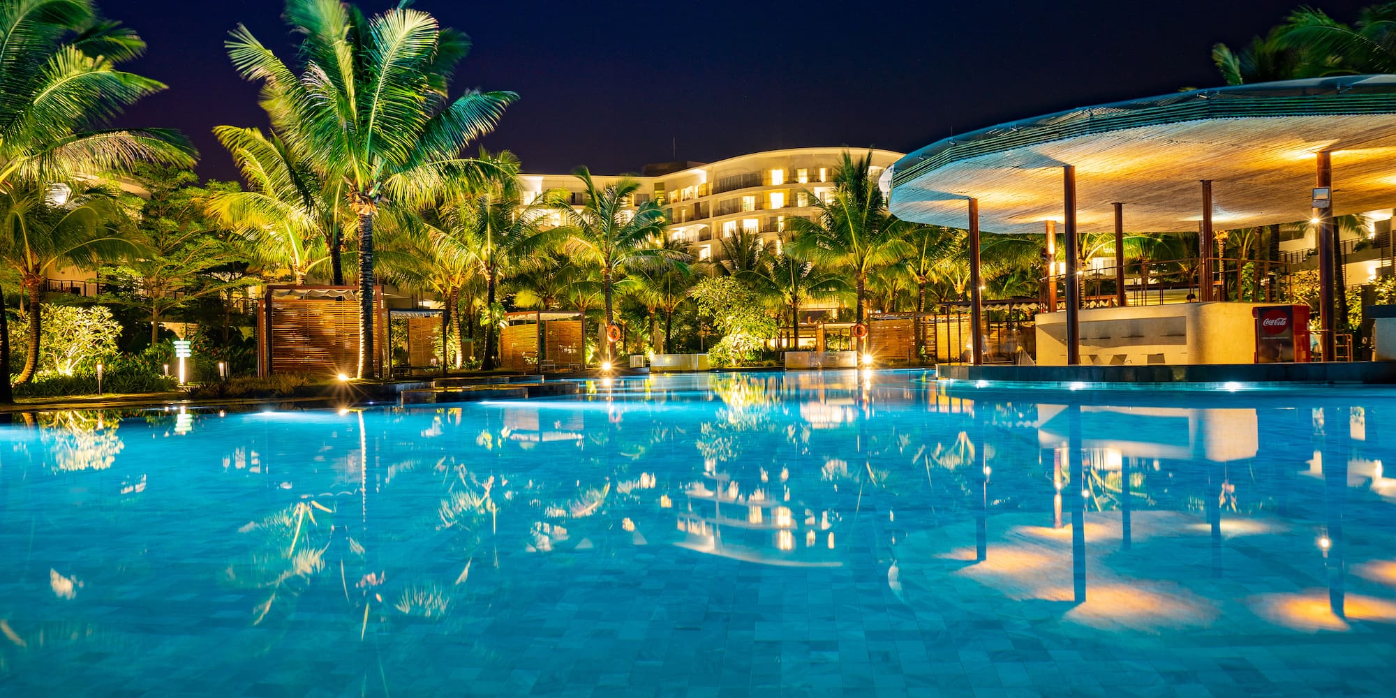 a pool with palm trees and buildings in the background