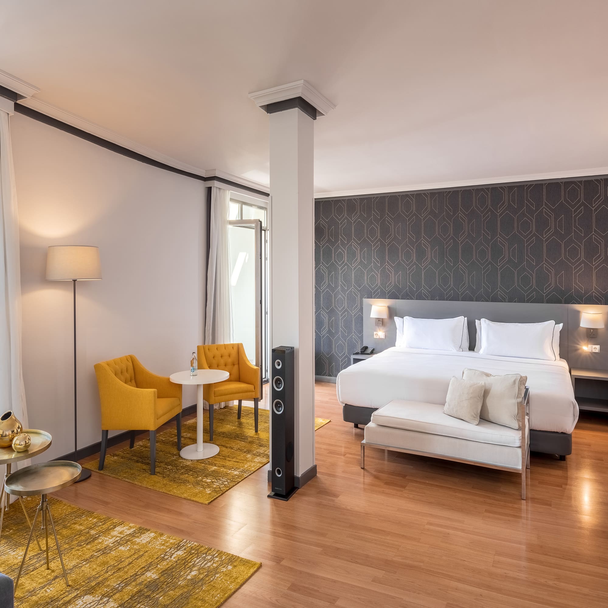 a room with a bed and chairs