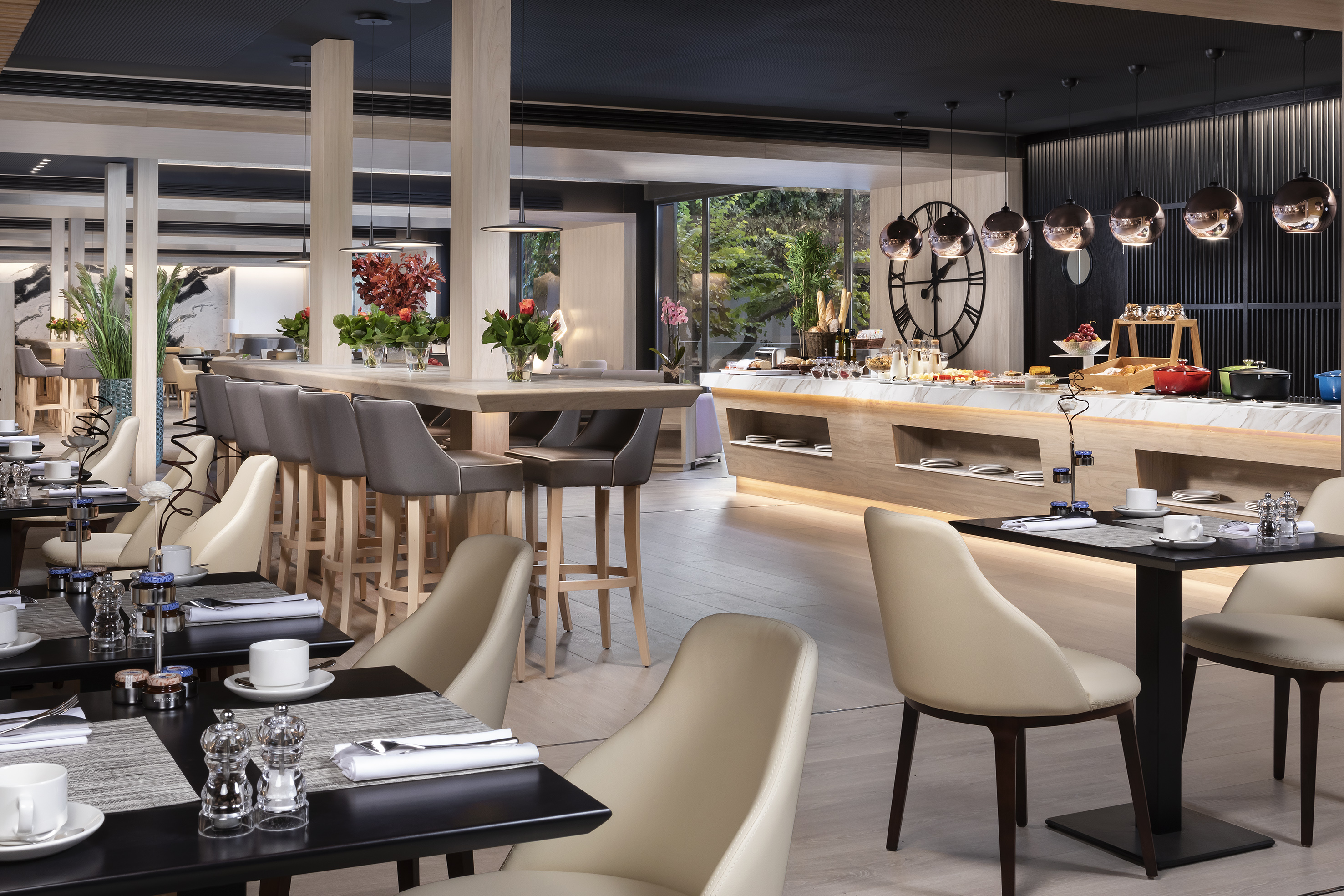 Elegant hotel restaurant buffet, dining tables, and bar seating.