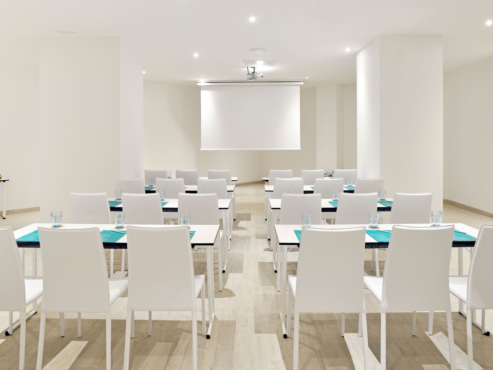 a room with white chairs and tables