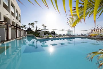 a pool with lounge chairs and umbrellas