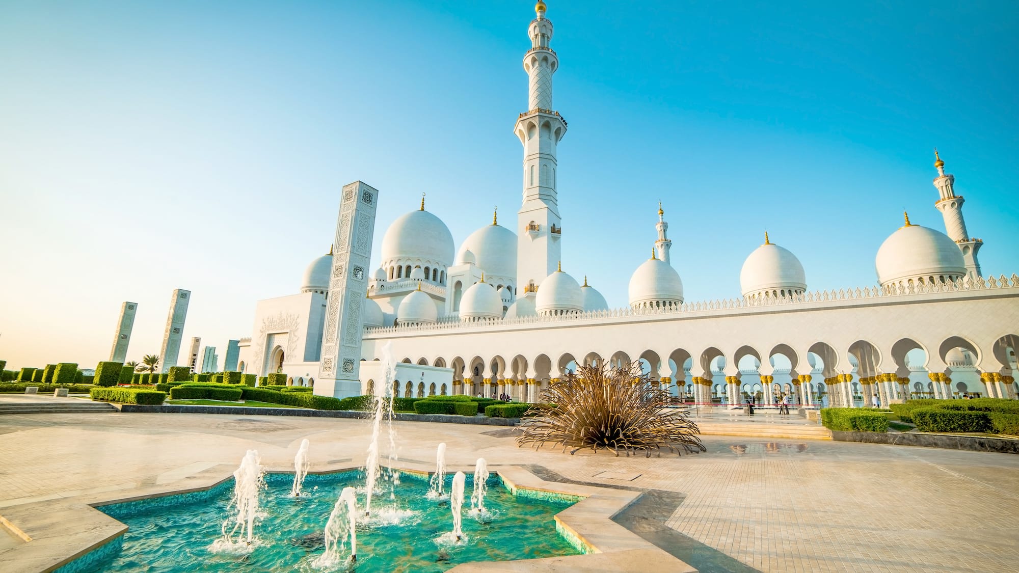 a large white building with domes and a fountain