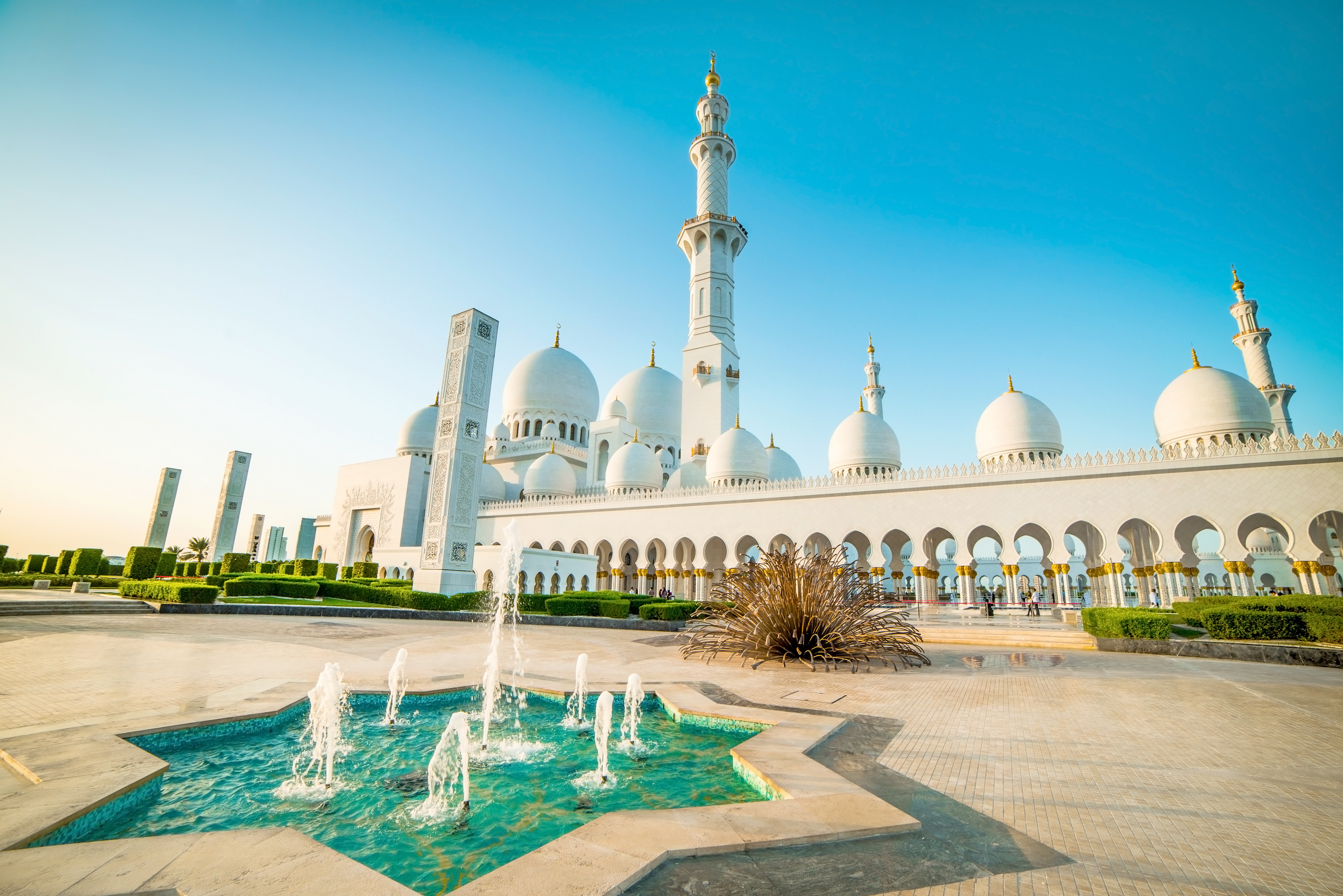a large white building with domes and a fountain