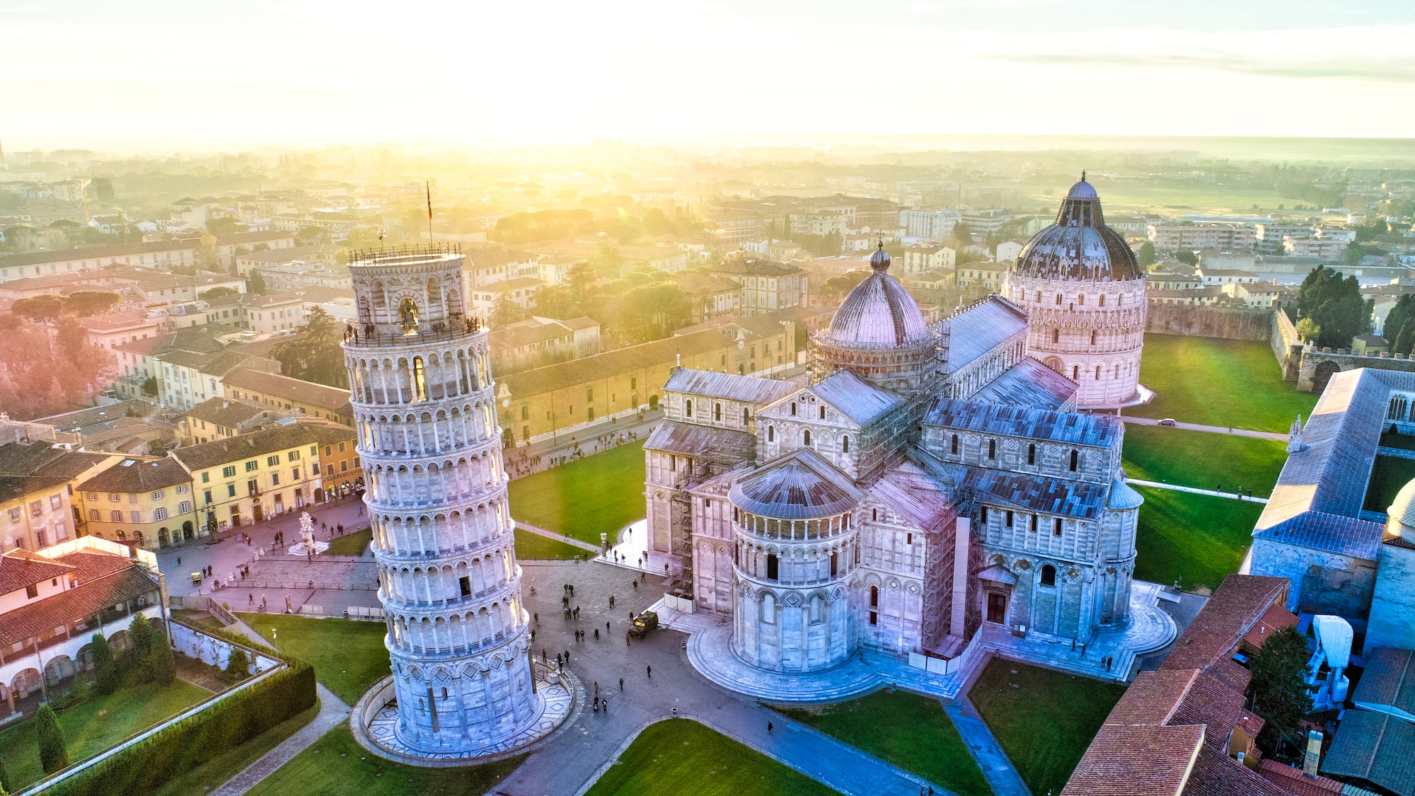 a tower of pisa with people walking around