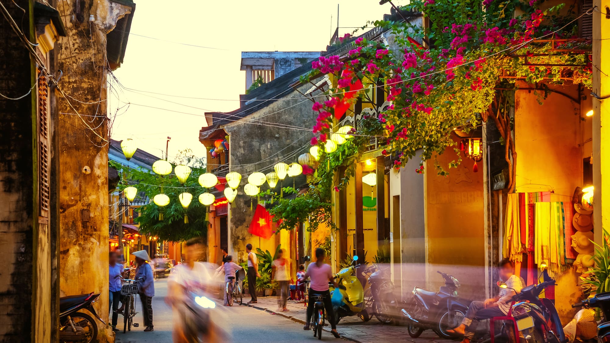 a street with people and motorcycles and lights