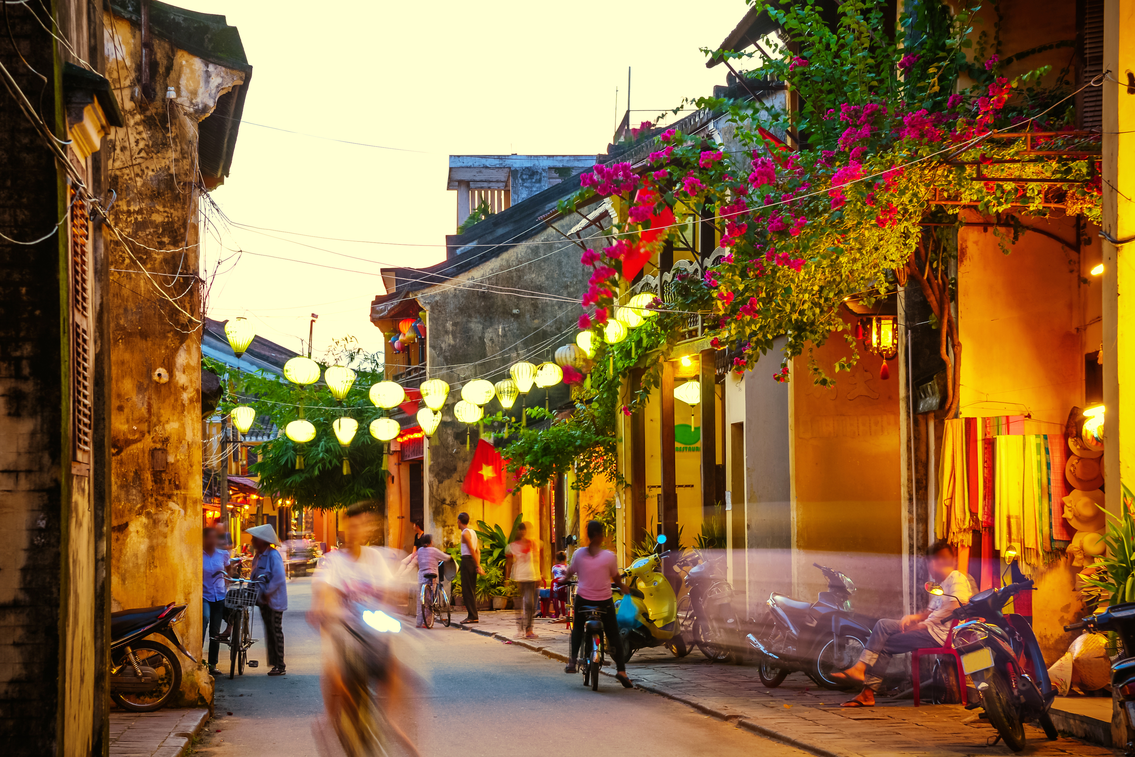 a street with people and motorcycles and lights