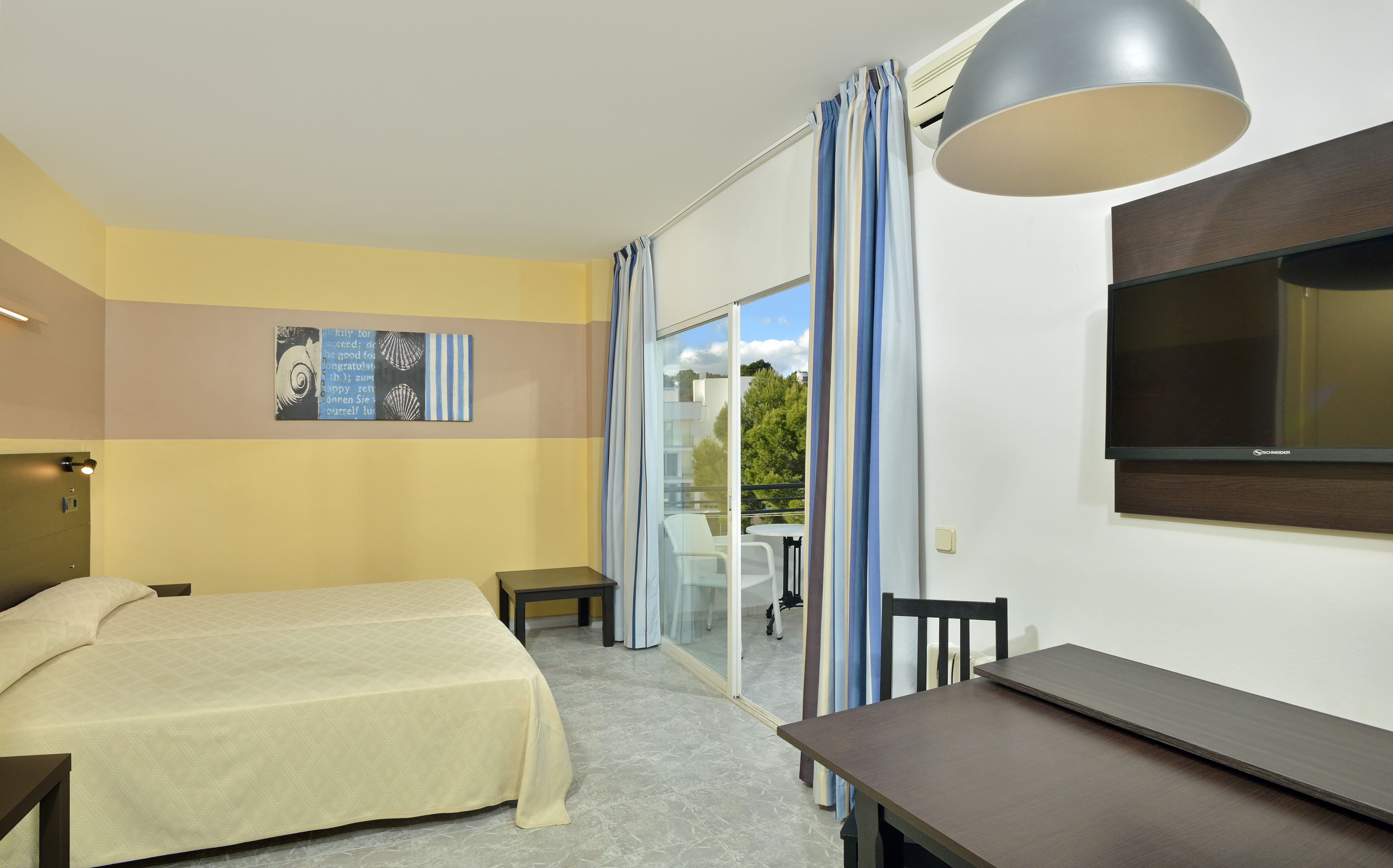 a room with a bed and a table and a television