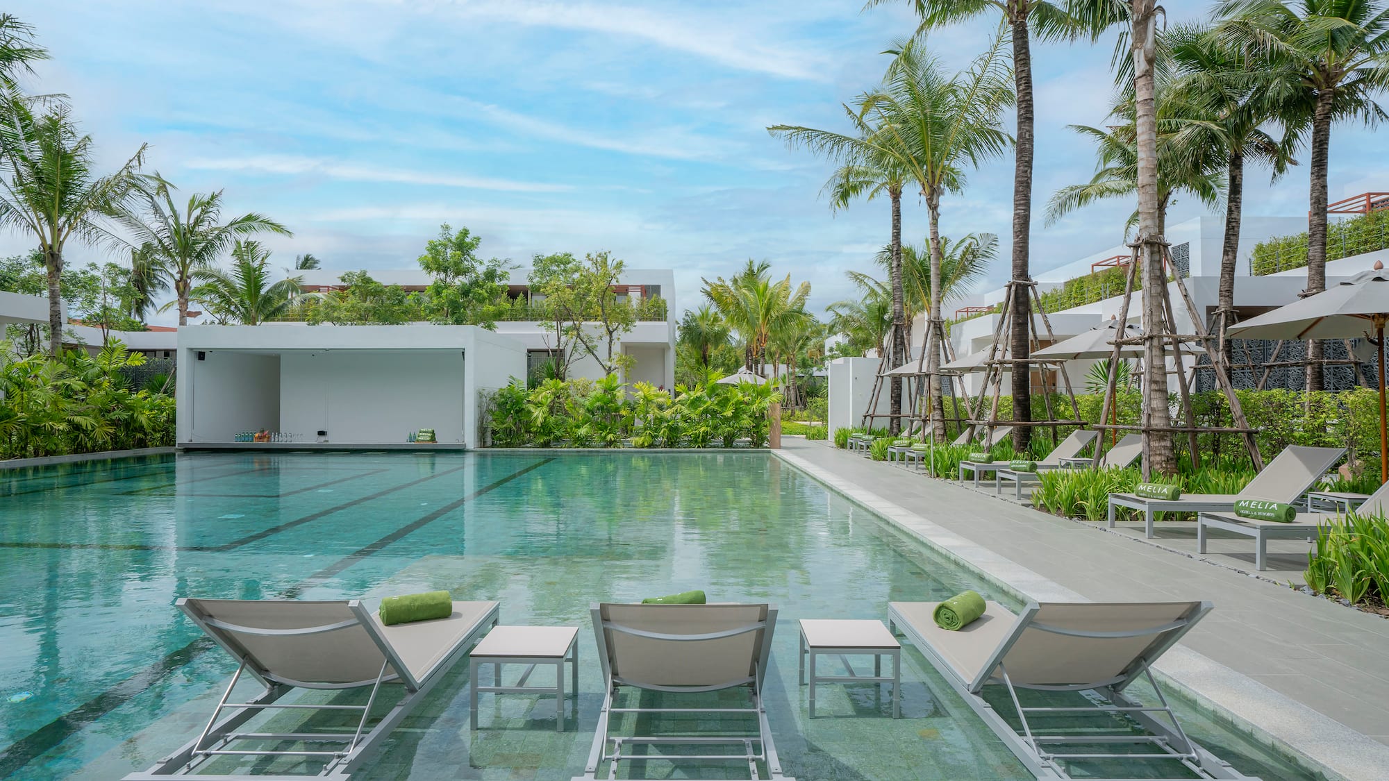 a pool with lounge chairs and palm trees