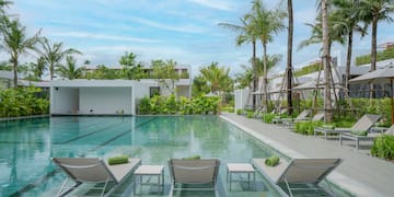 a pool with lounge chairs and palm trees
