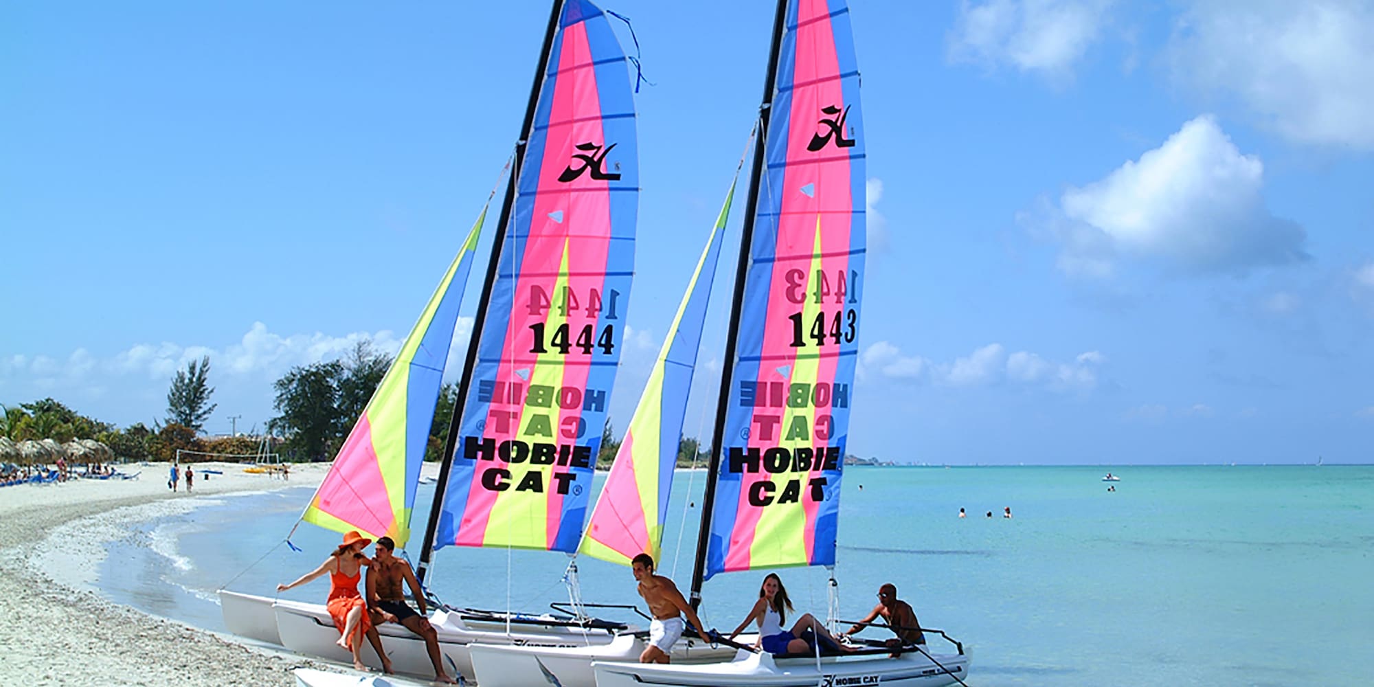 a group of people on a sailboat on a beach
