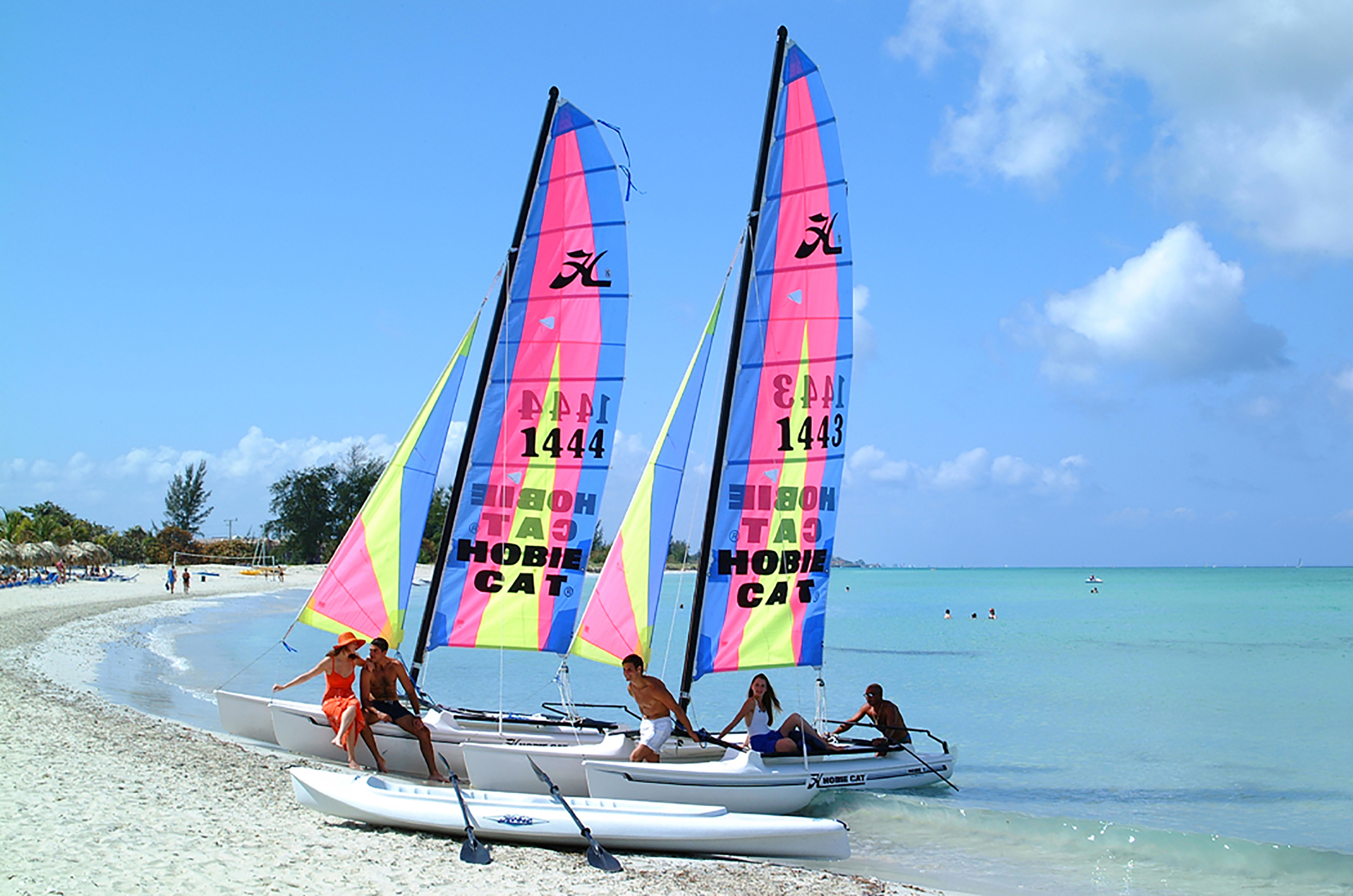 a group of people on a sailboat on a beach