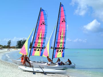 a group of people on a sailboat on a beach