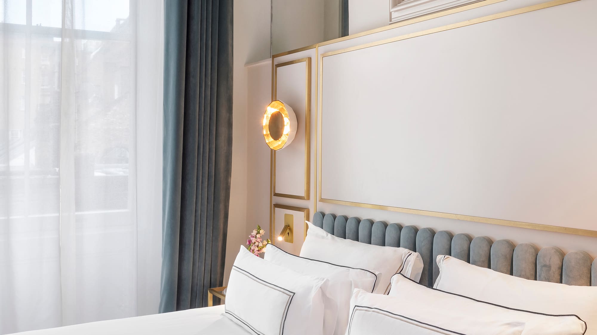 a bed with white sheets and pillows