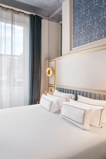 a bed with white sheets and pillows