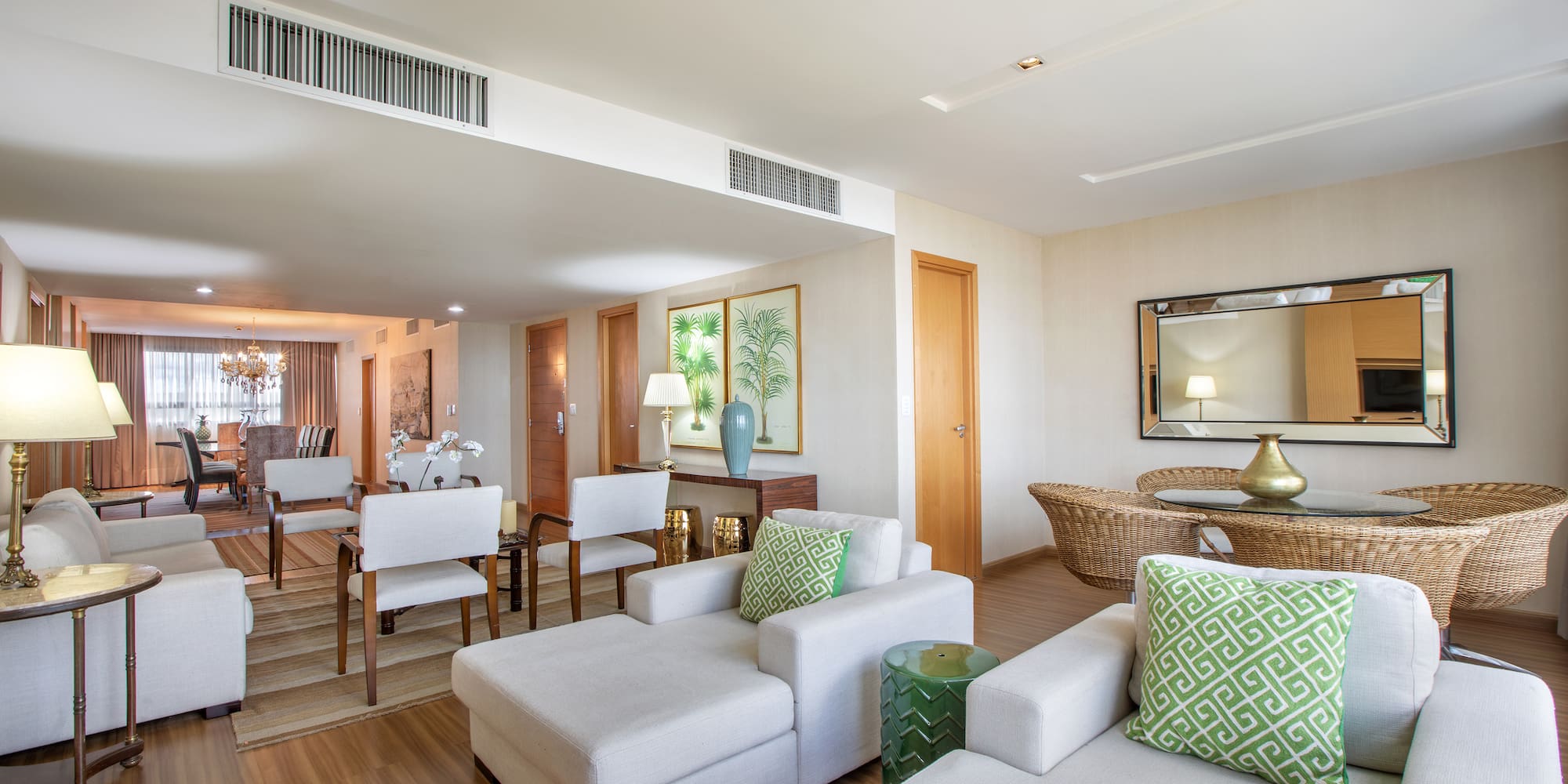 a living room with white furniture and a wood floor