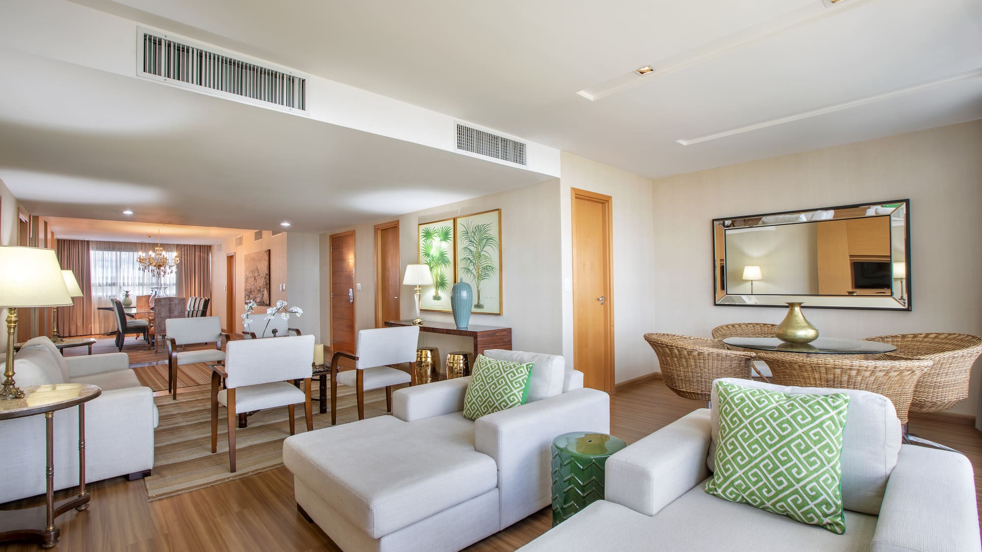 a living room with white furniture and a wood floor
