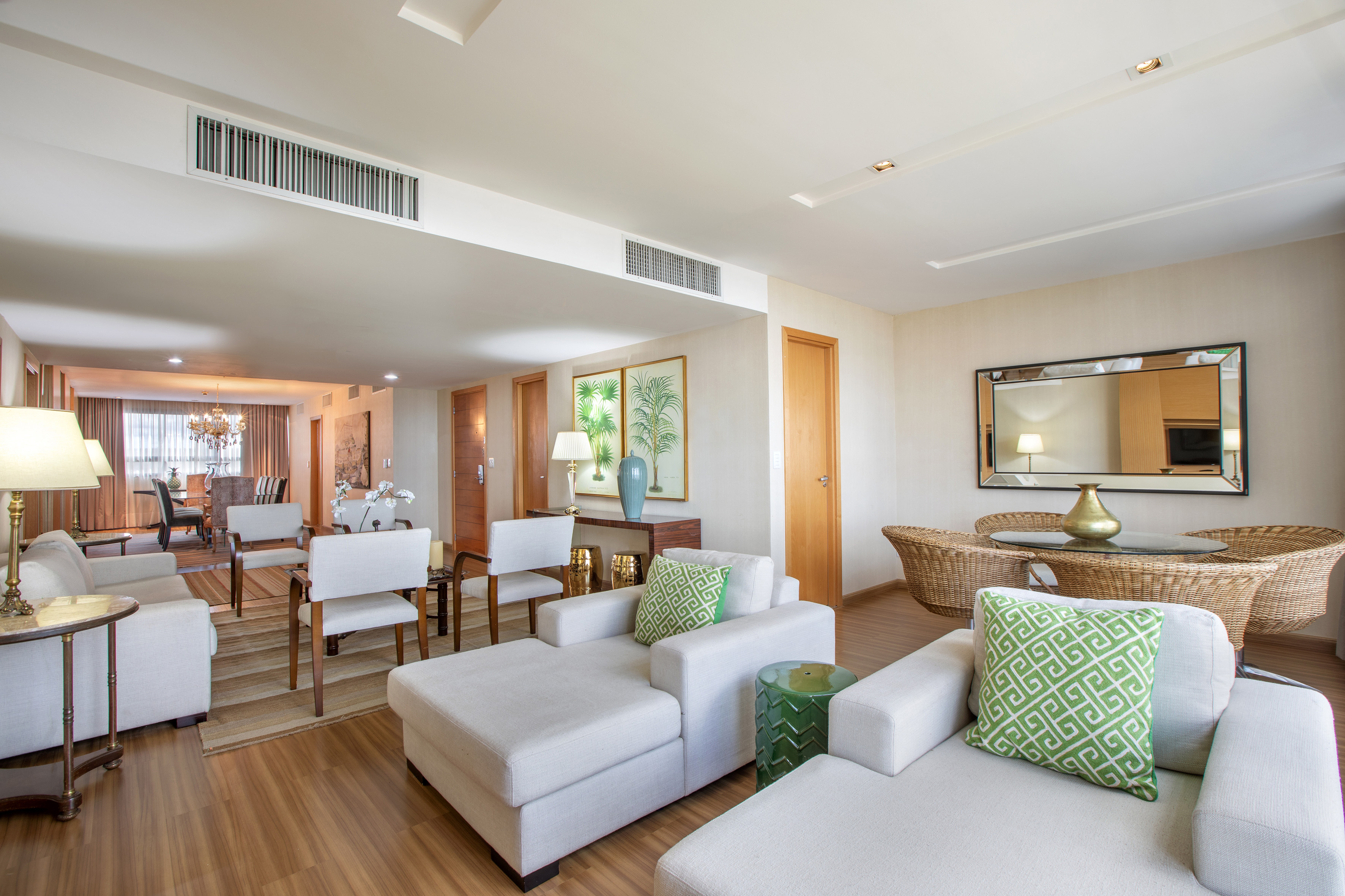 Neutral modern living & dining room, wood floors, green accents.