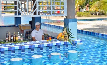 a man behind a bar with drinks