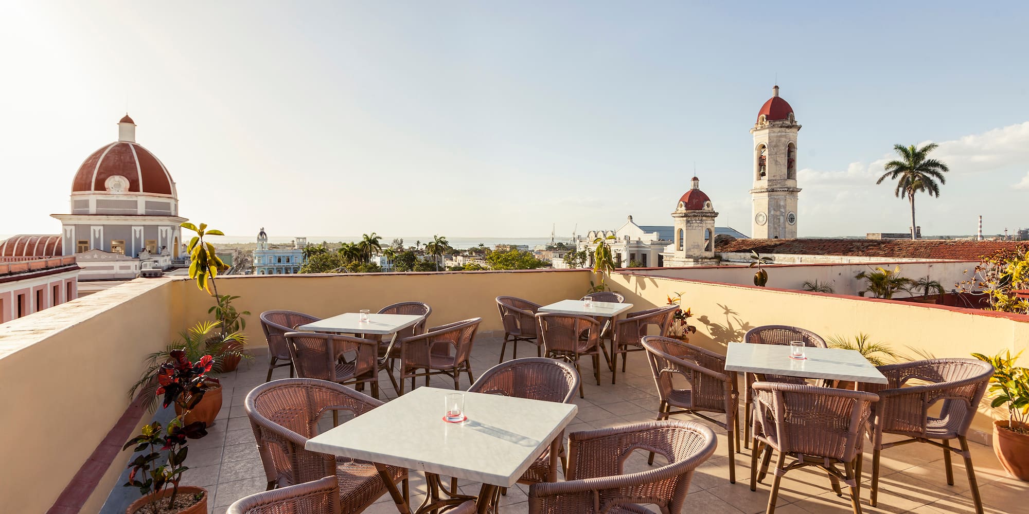 a patio with tables and chairs on a rooftop