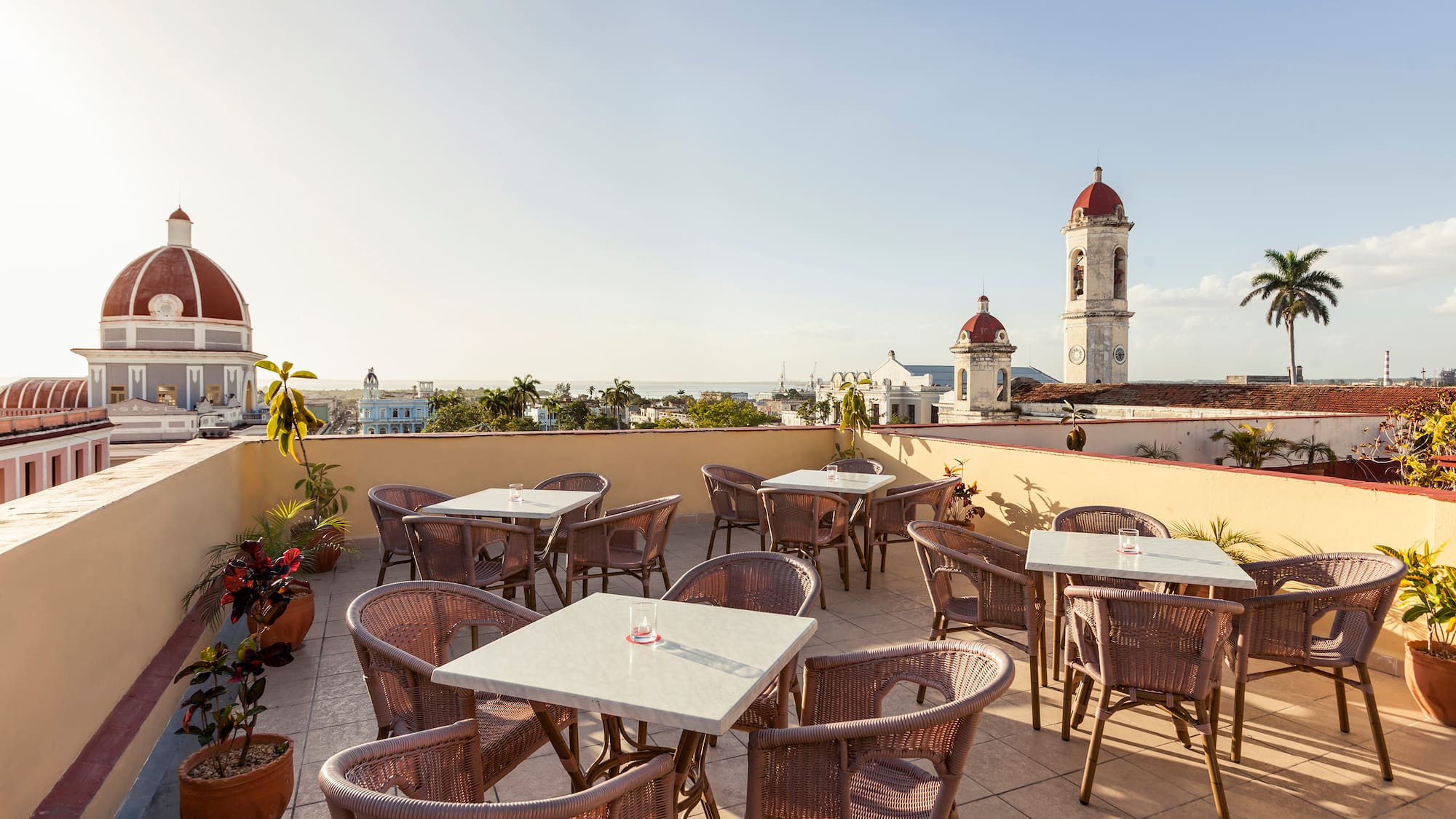a patio with tables and chairs on a rooftop