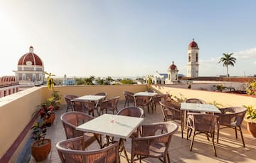 a patio with tables and chairs on a rooftop