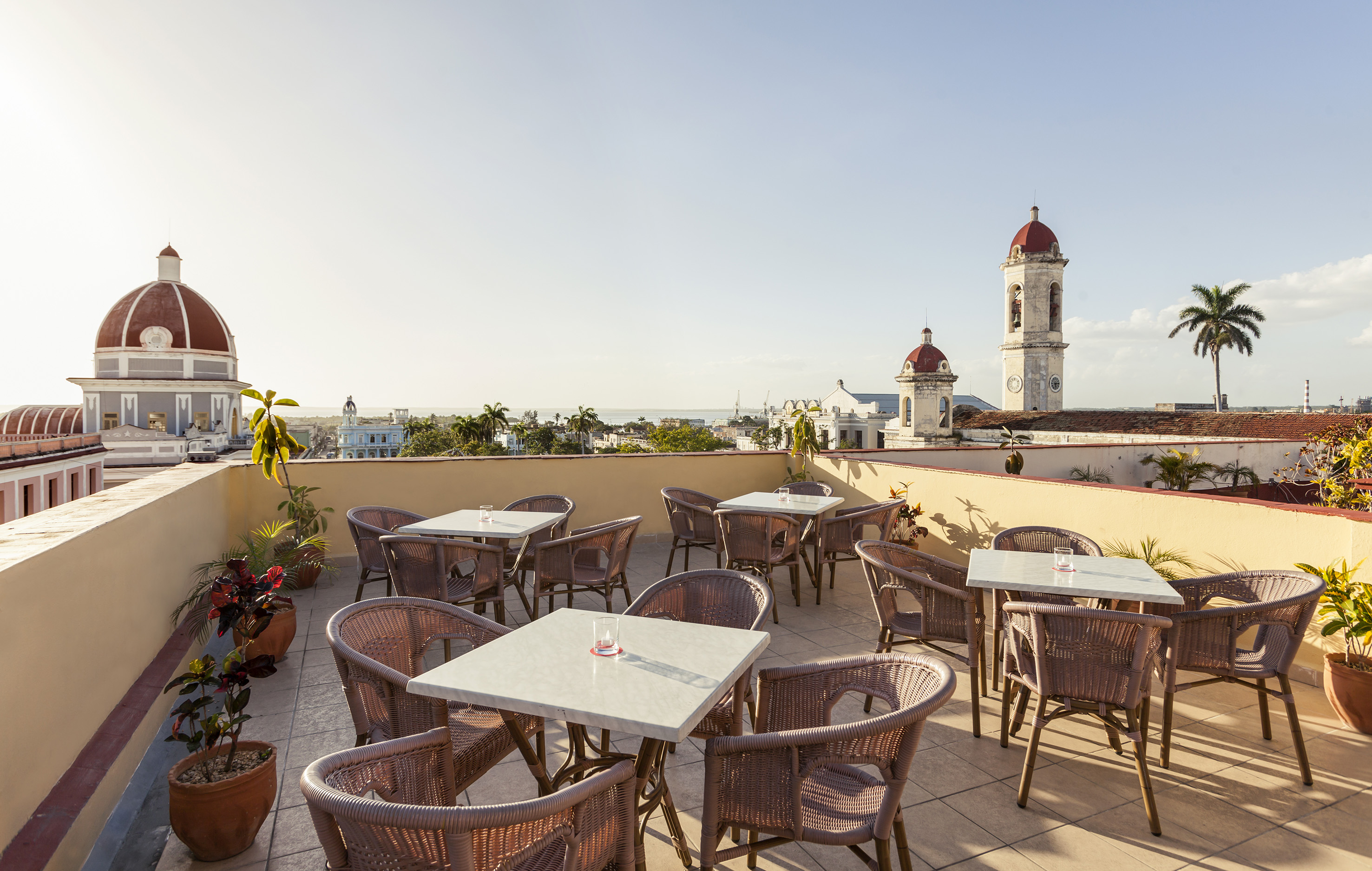 a patio with tables and chairs on a rooftop