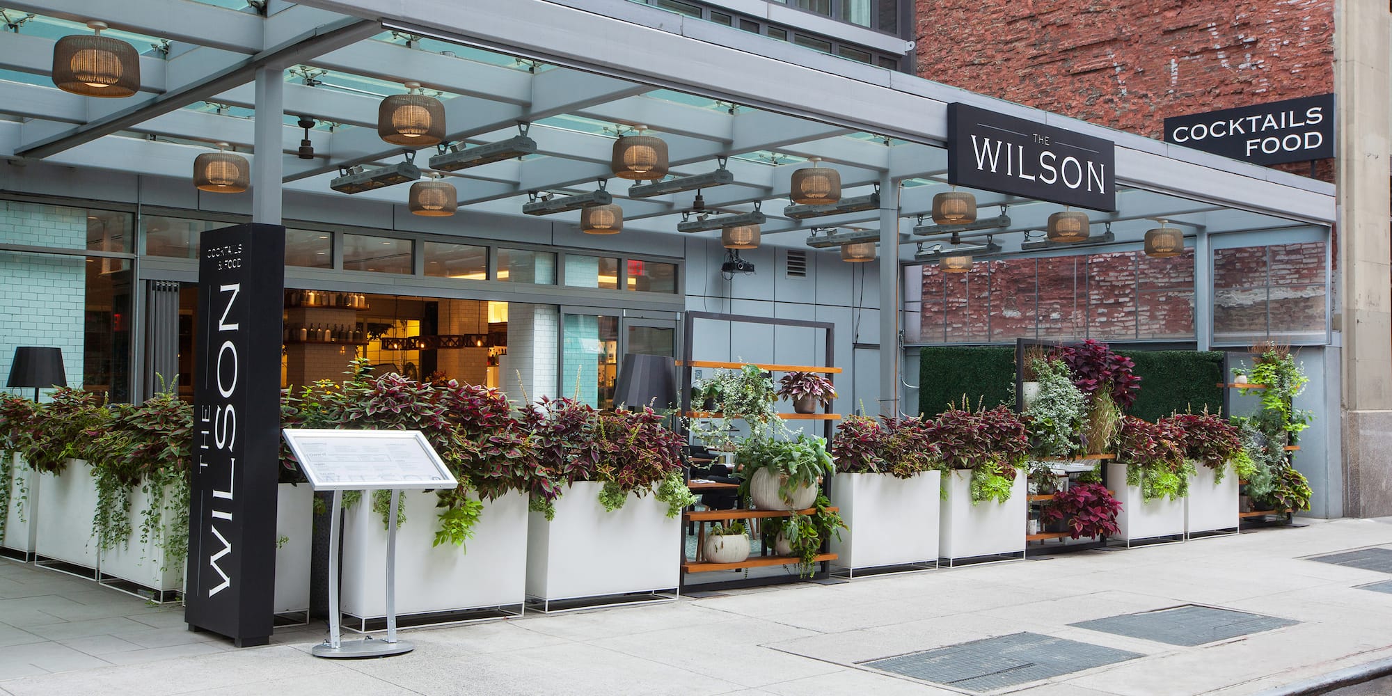 a building with a sign and plants