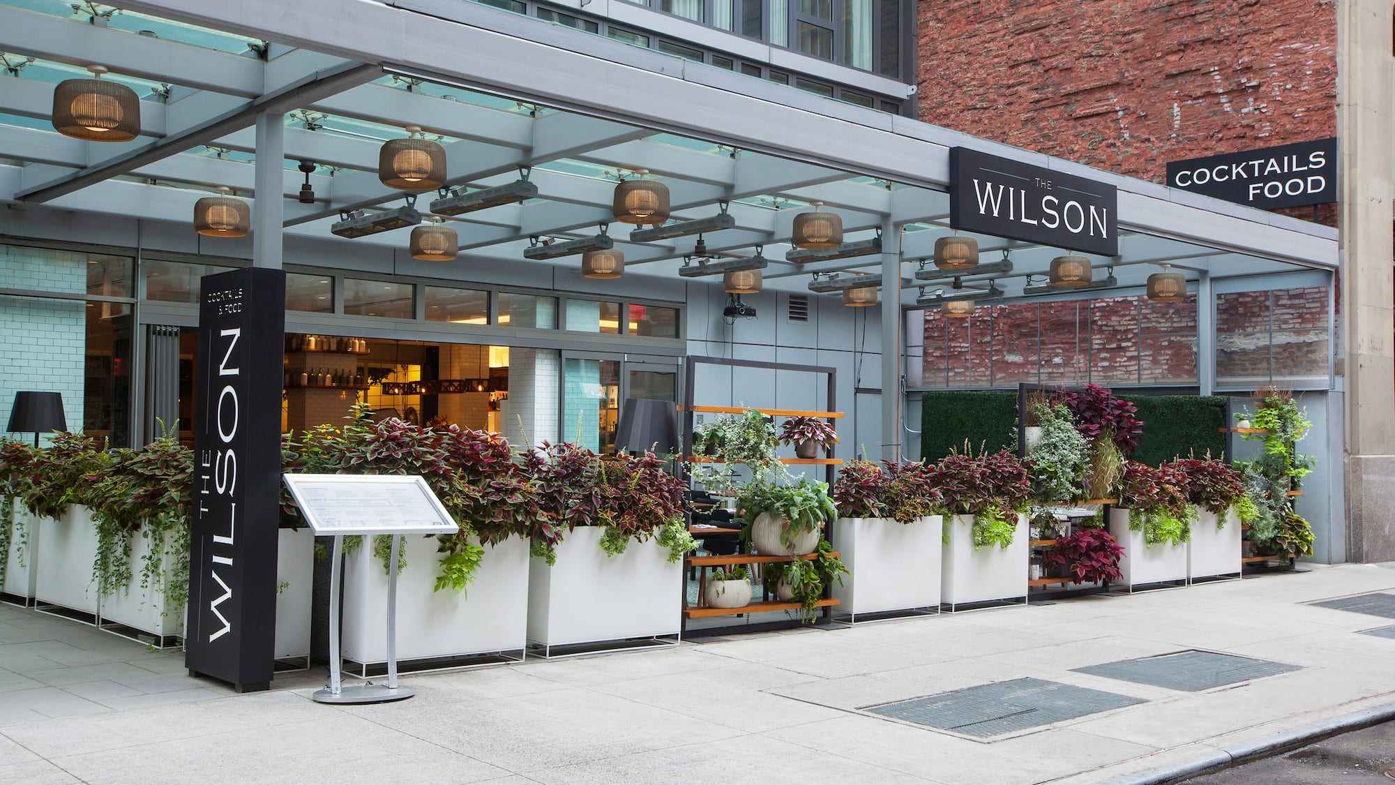 a building with a sign and plants