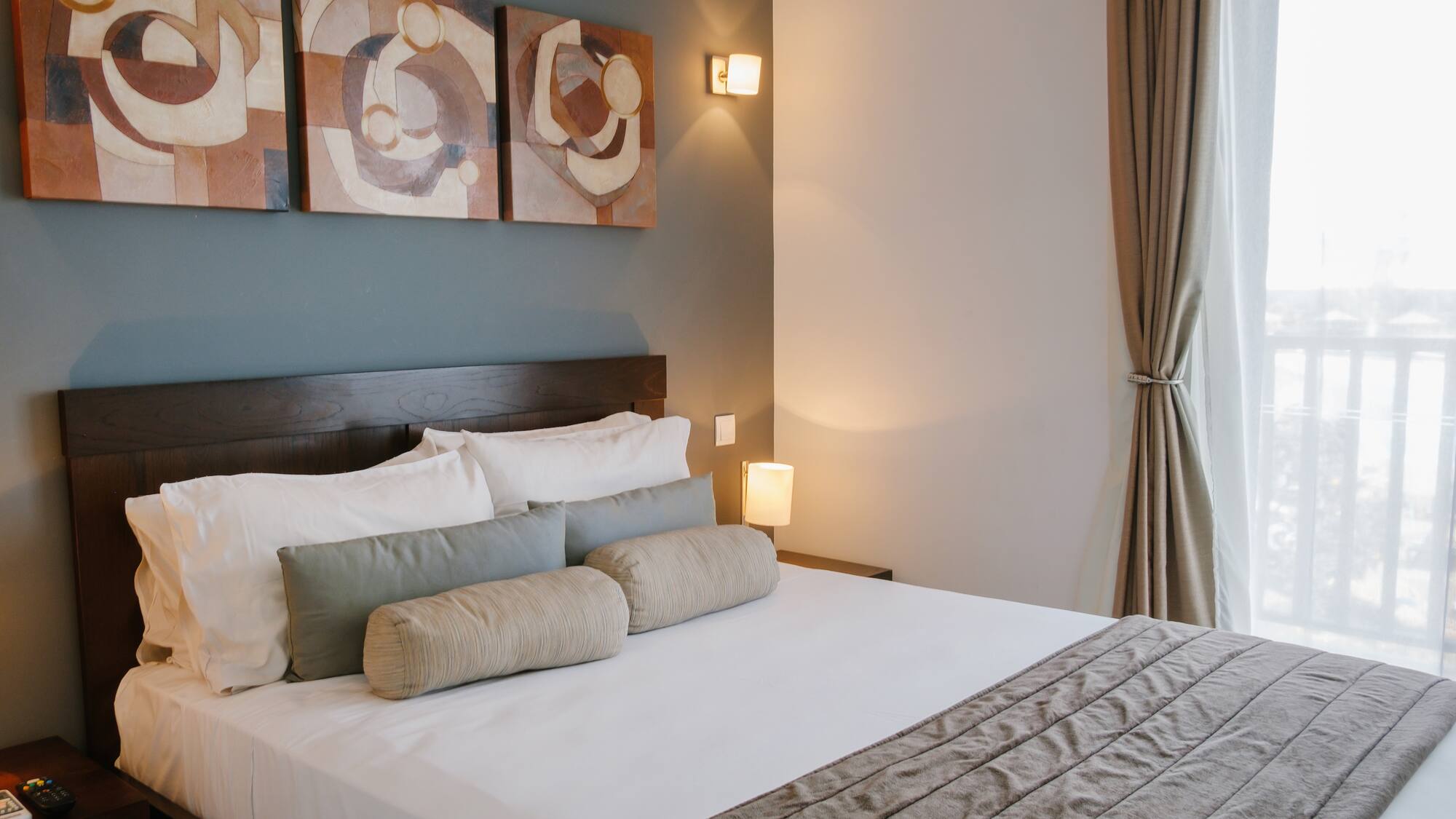 a bed with pillows and a lamp on the wall