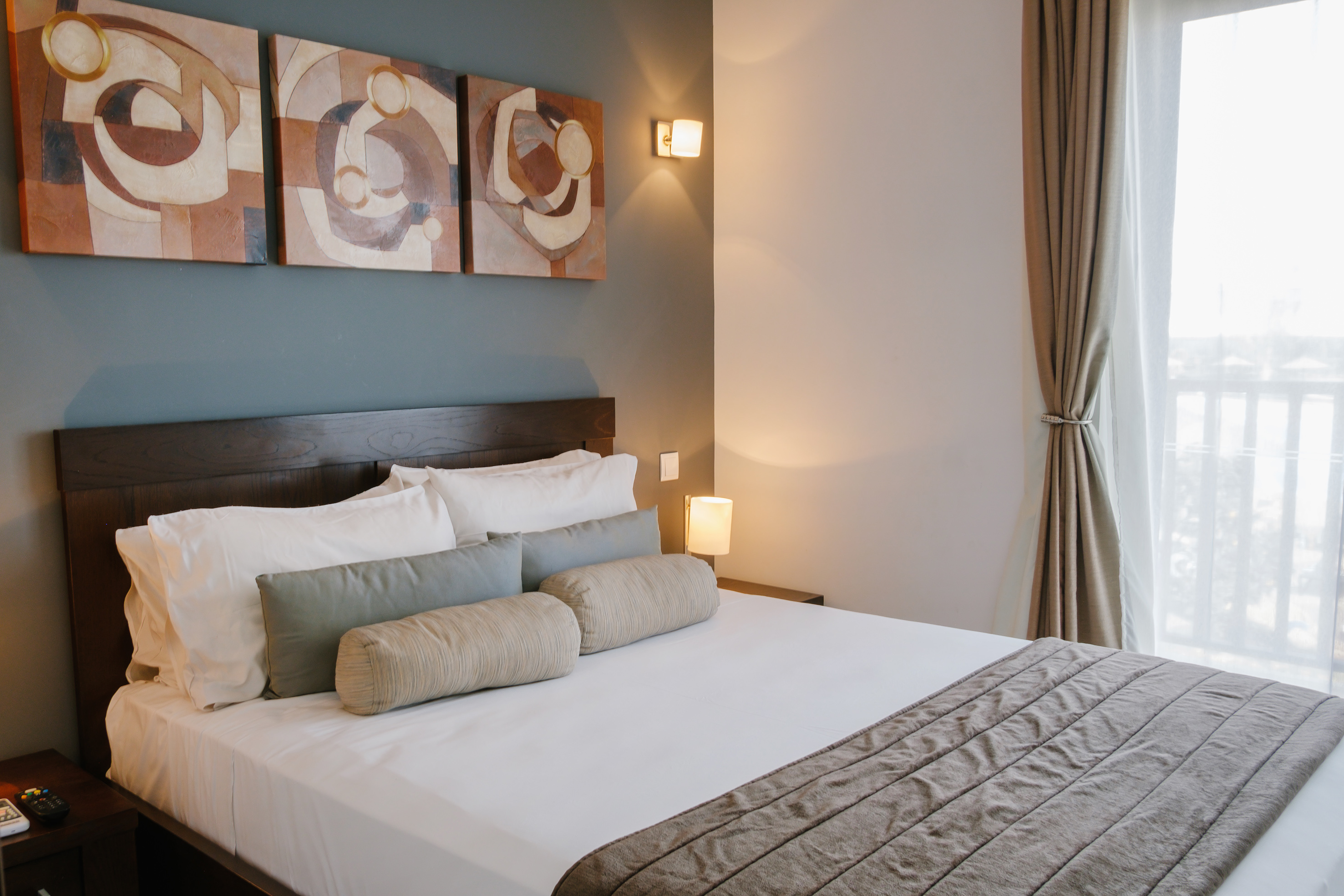 a bed with pillows and a lamp on the wall