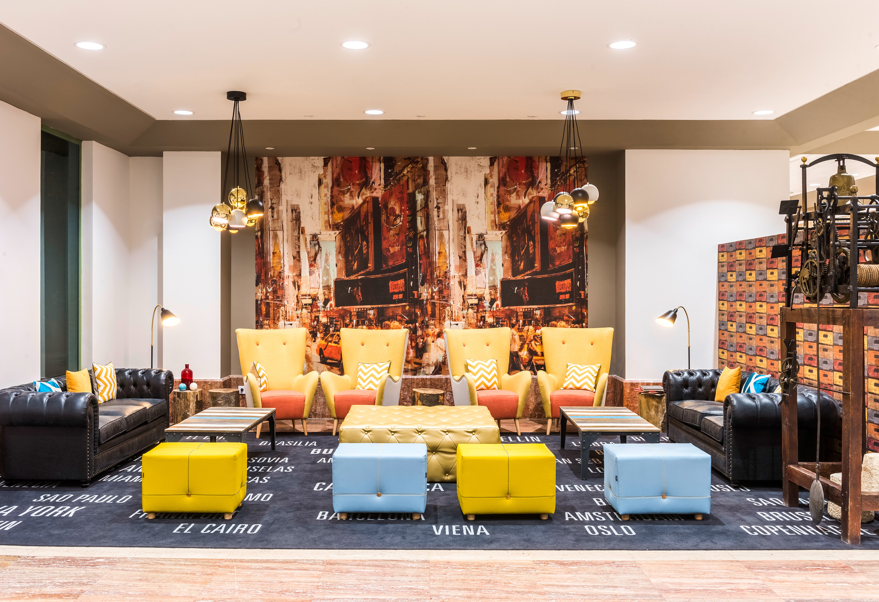 Colorful hotel lobby lounge with modern seating, city mural, and map rug.