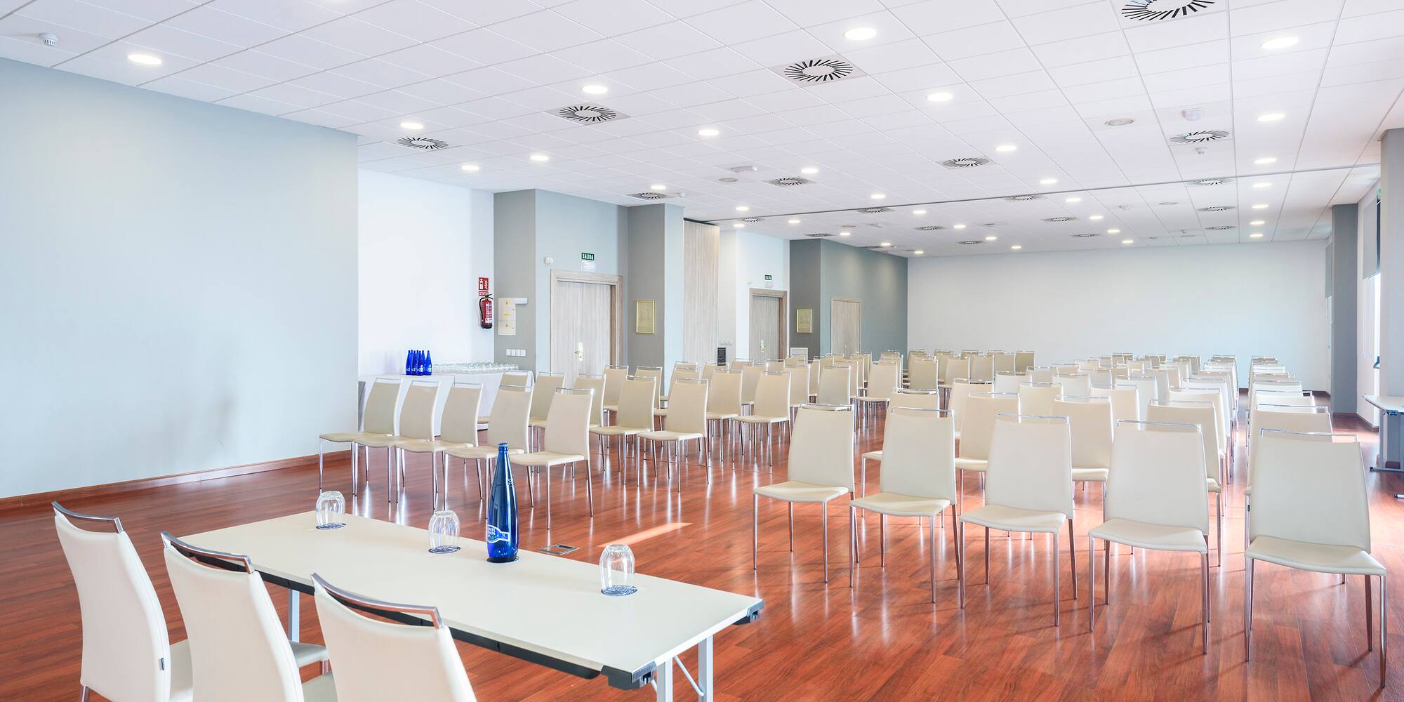 a room with white chairs and tables