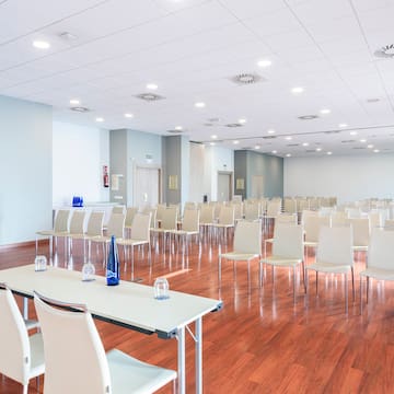 a room with white chairs and tables