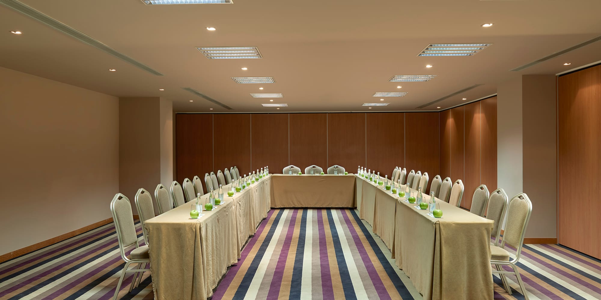 a long table set up in a room with chairs and a table with candles
