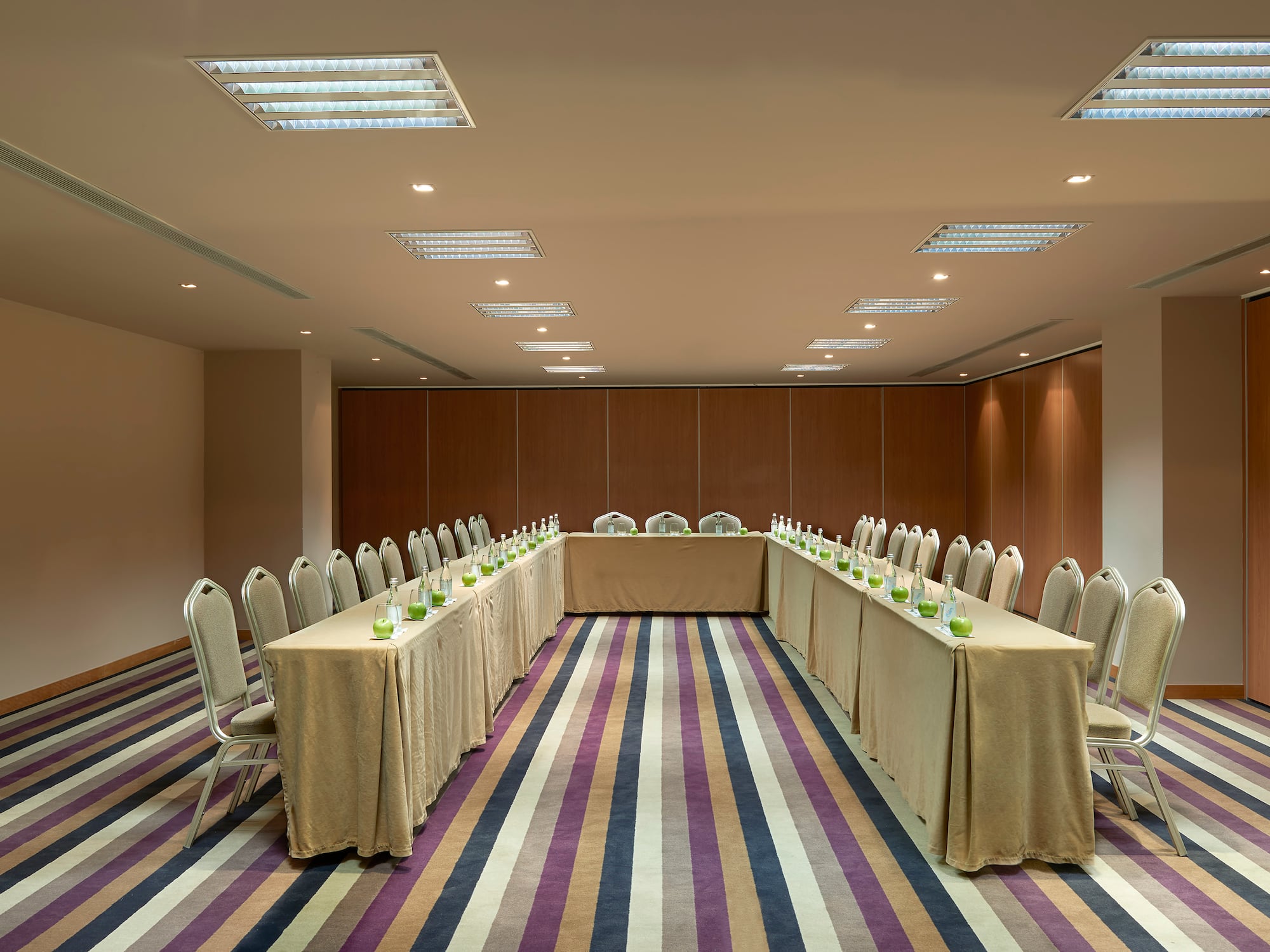 a long table set up in a room with chairs and a table with candles