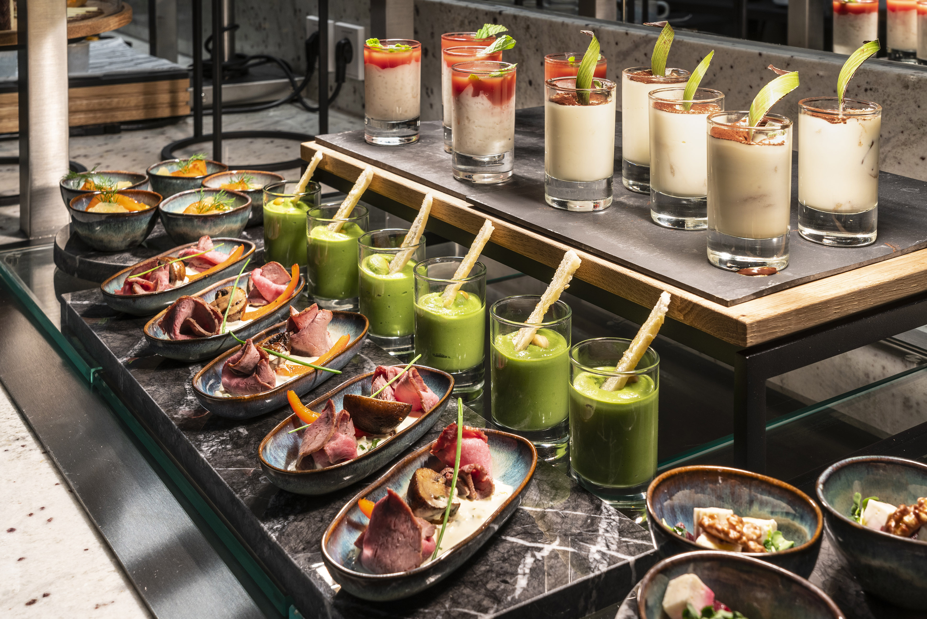 Elegant buffet spread with diverse mini appetizers, soups, and desserts.