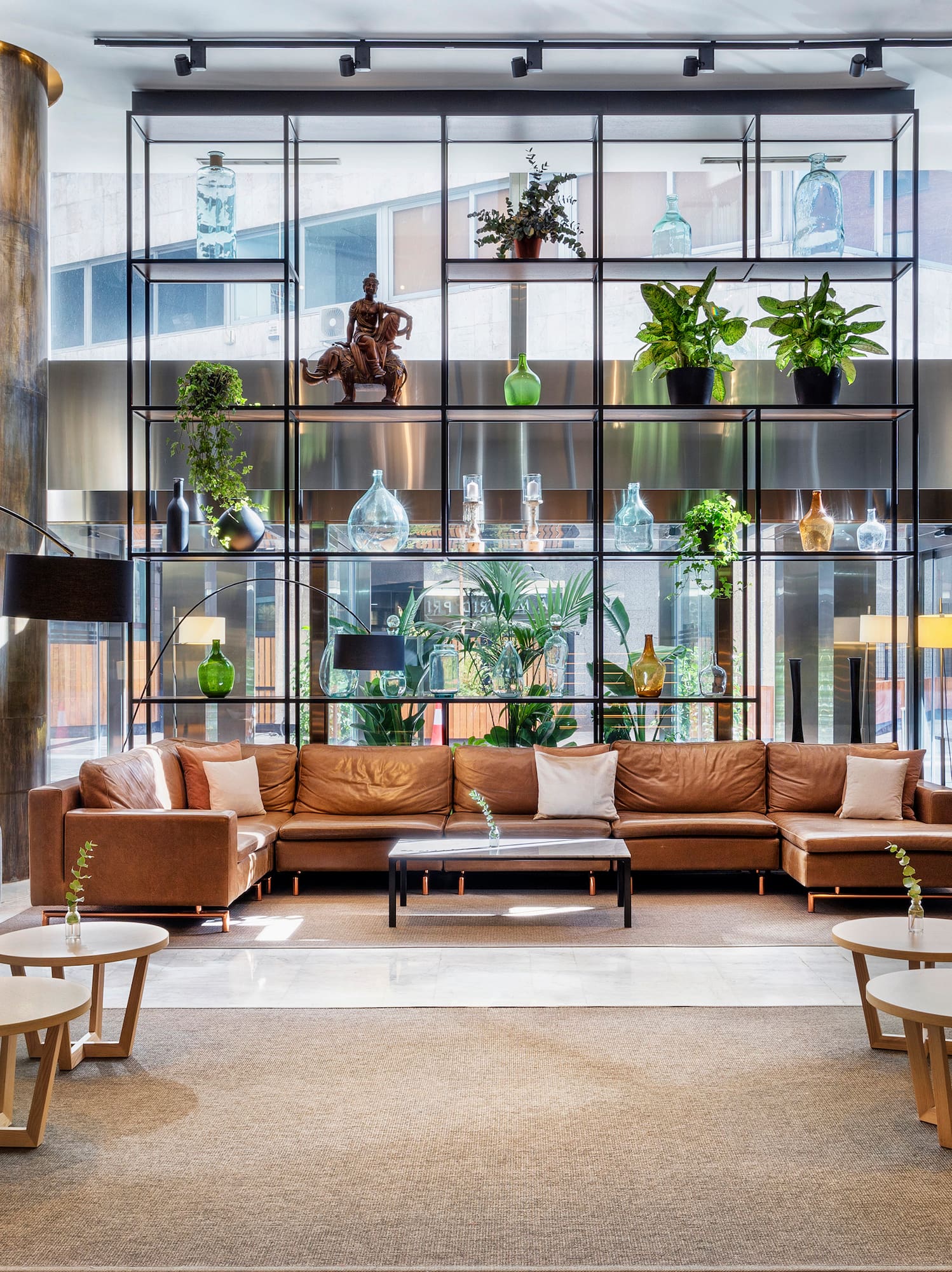 a room with a large couch and a tall glass wall