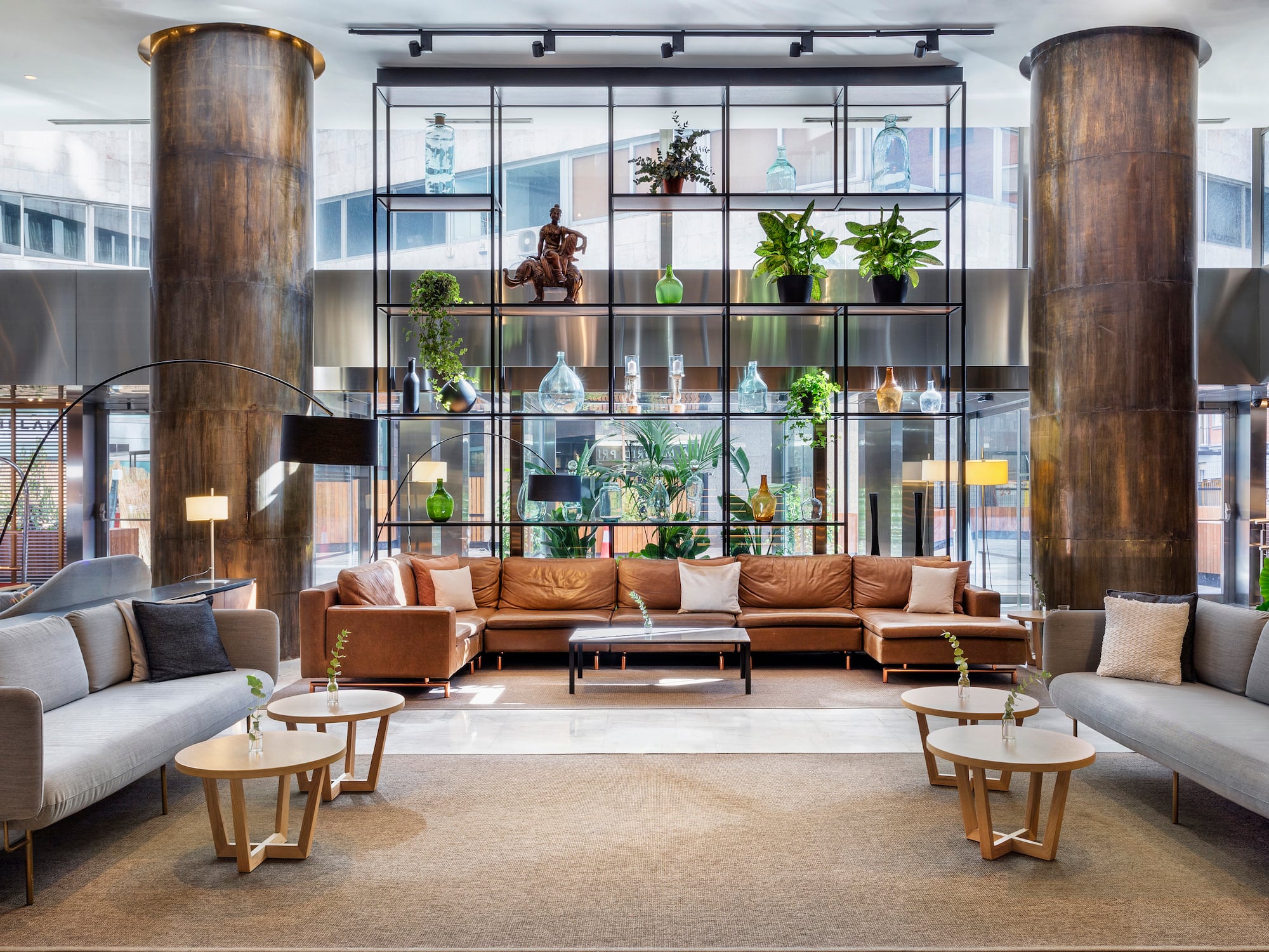 a room with a large couch and a tall glass wall