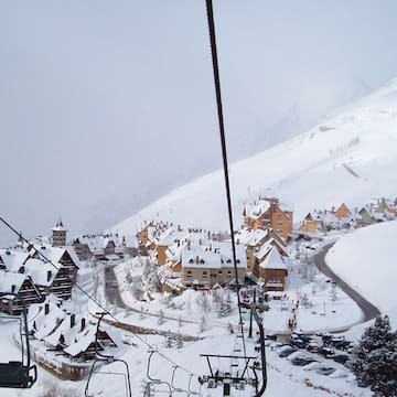 a ski lift with houses and snow on the ground