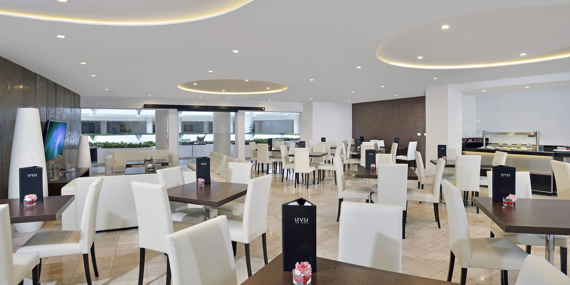 a room with white chairs and tables