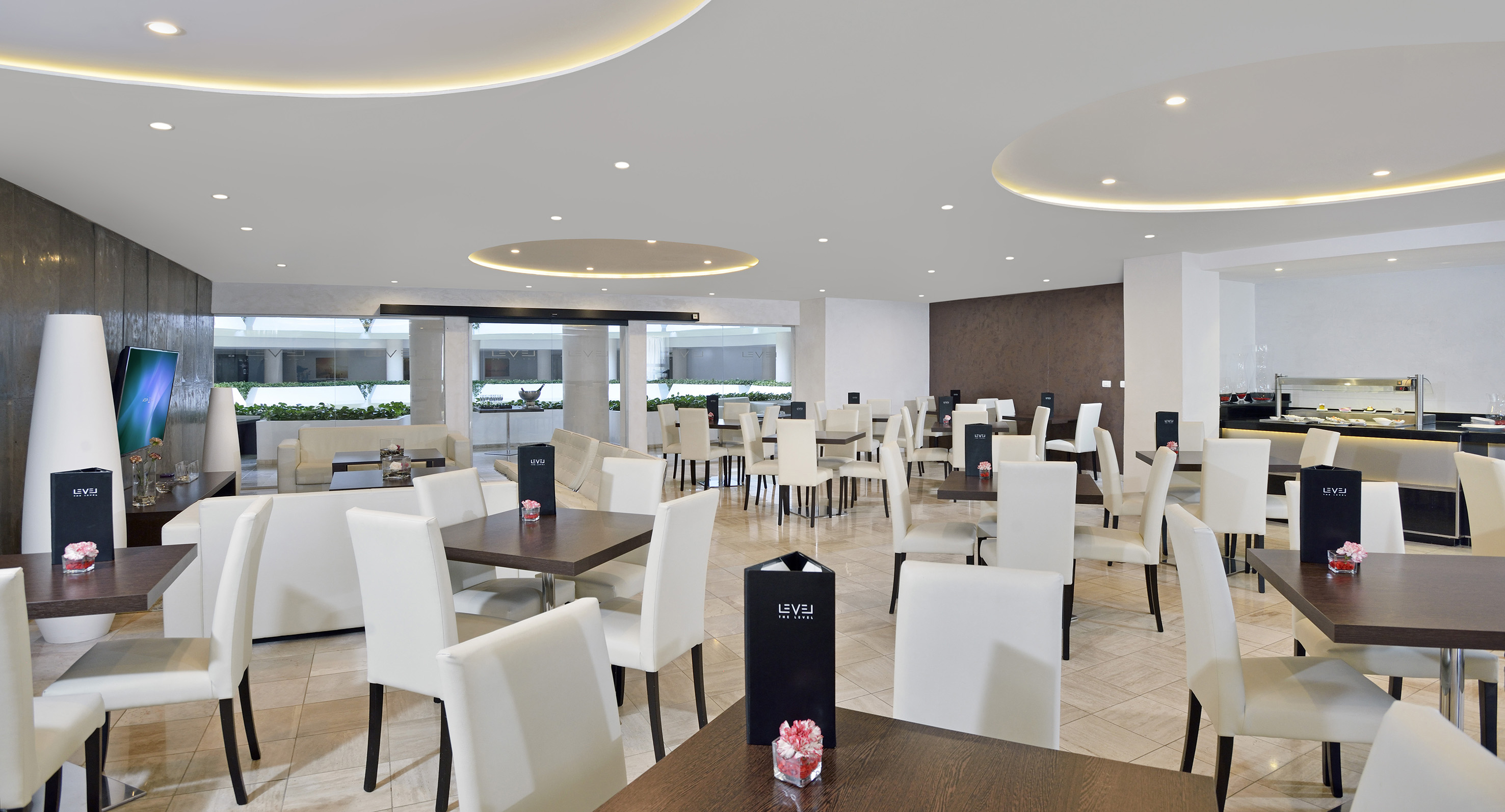 a room with white chairs and tables