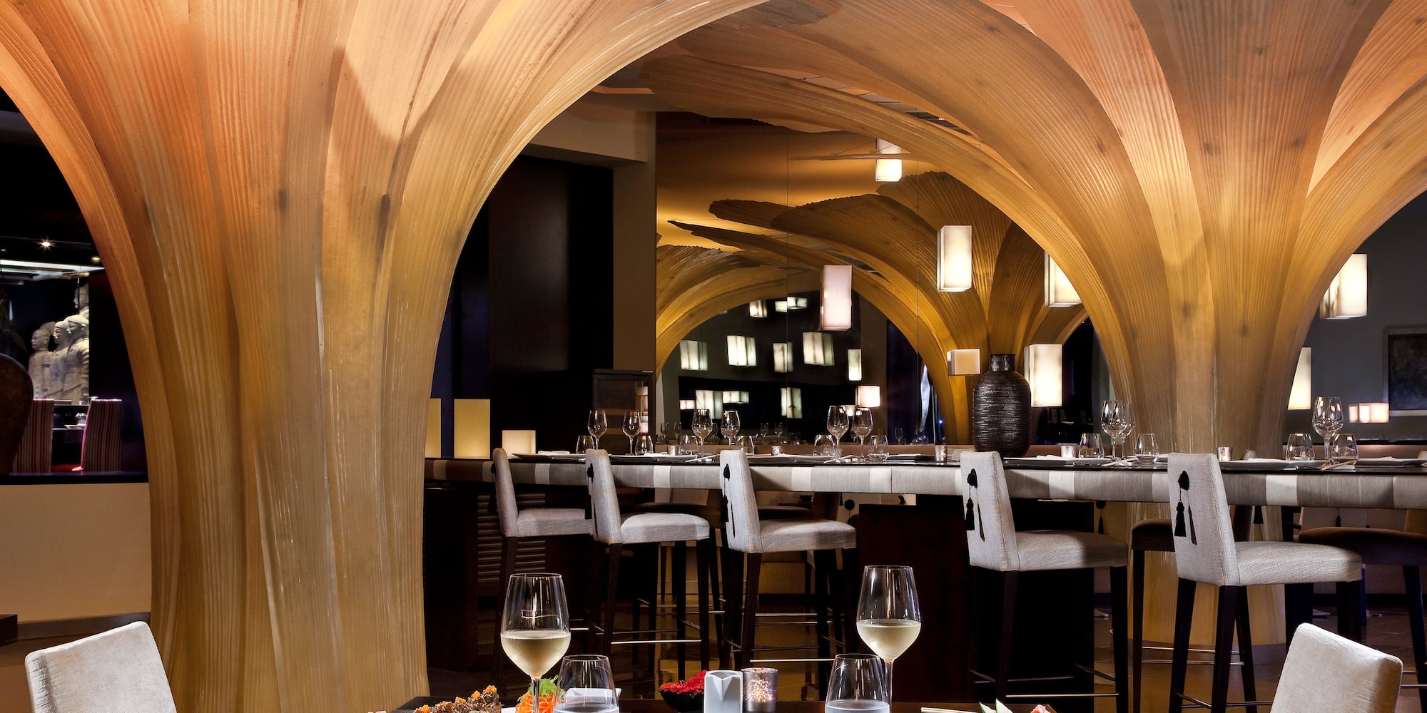 a restaurant with a table of food and glasses of wine