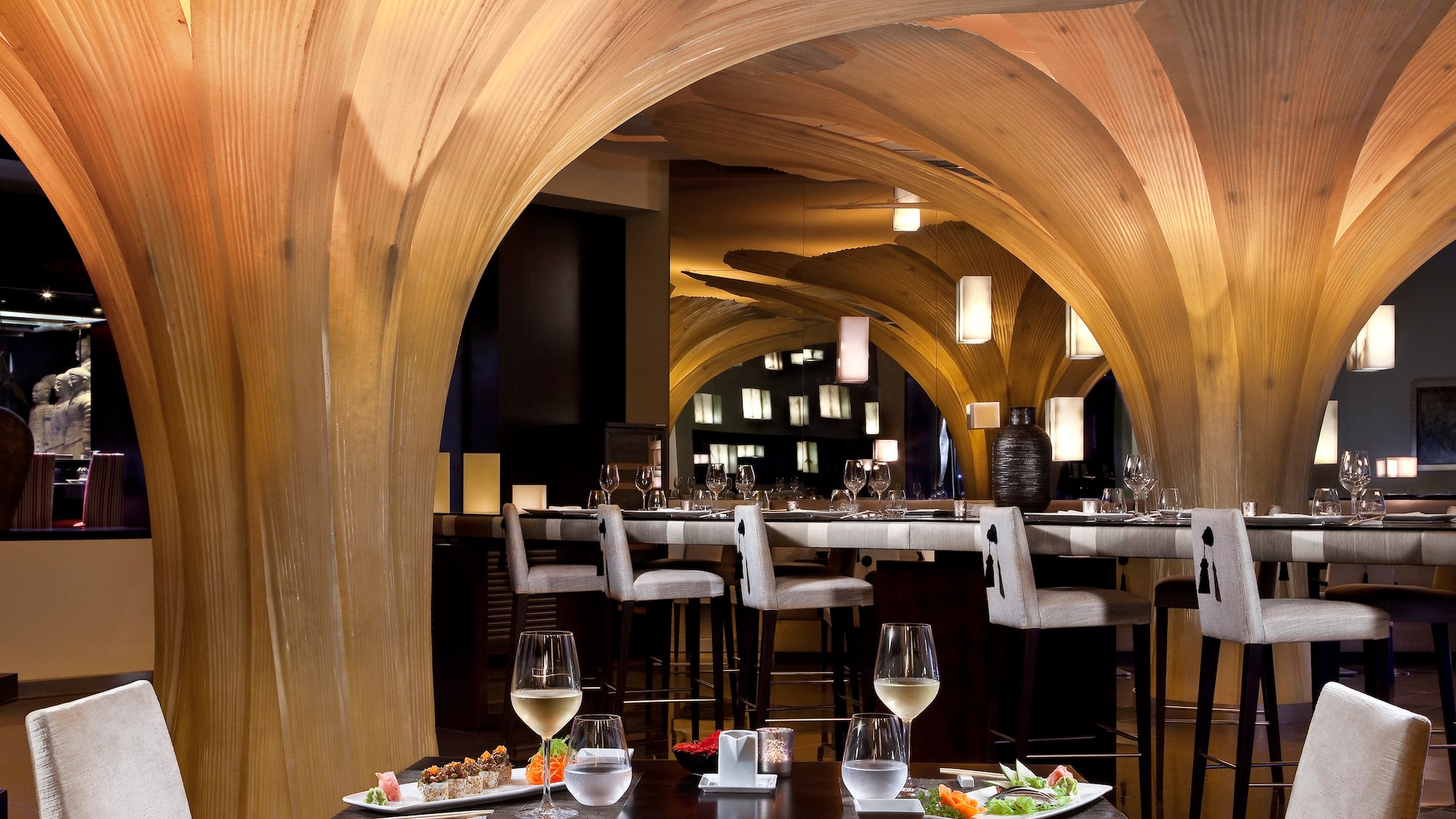 a restaurant with a table of food and glasses of wine