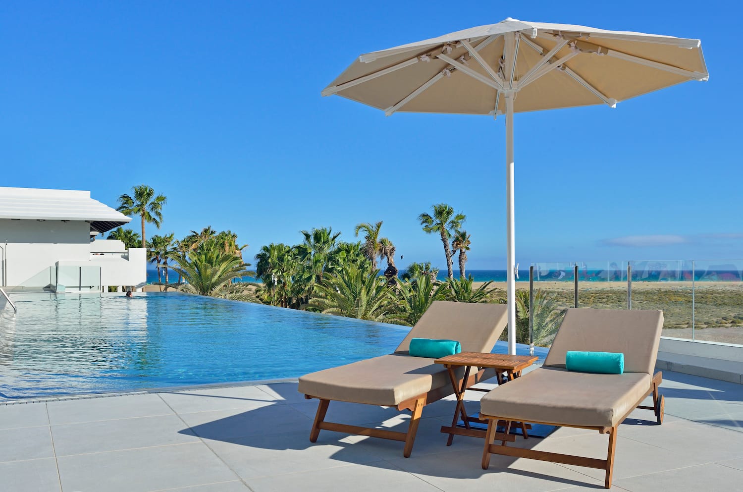 a pool with a deck chair and umbrella