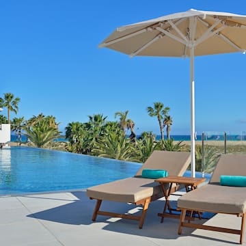 a pool with a deck chair and umbrella