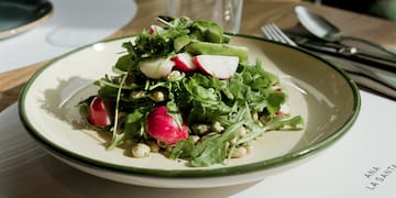 a plate of salad with radishes and greens