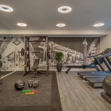 a gym with exercise equipment and a wallpaper